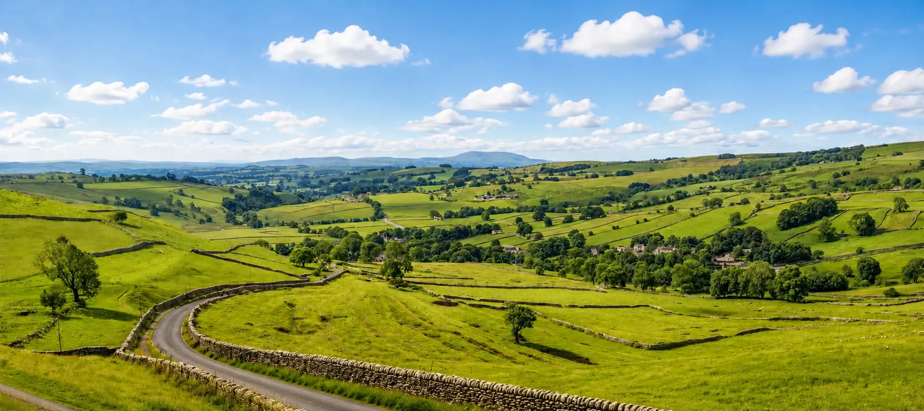 Rolling Cotswolds hills under a wide summer sky